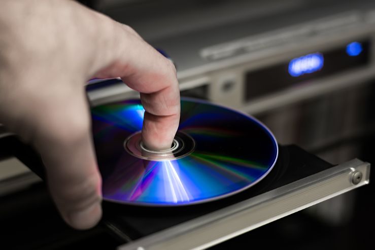 Osoba vklad disk do zapnutho DVD prehrvaču