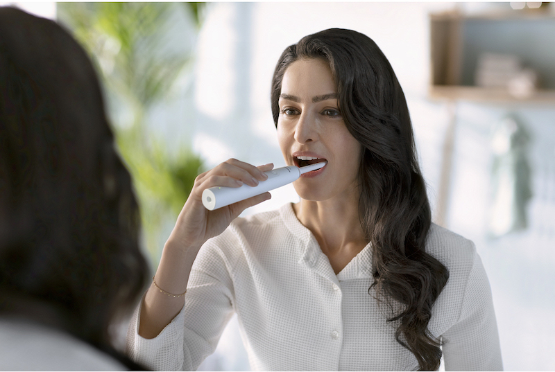 Elektrick zubn kefka Philips, pomocou ktorej si žena umva zuby