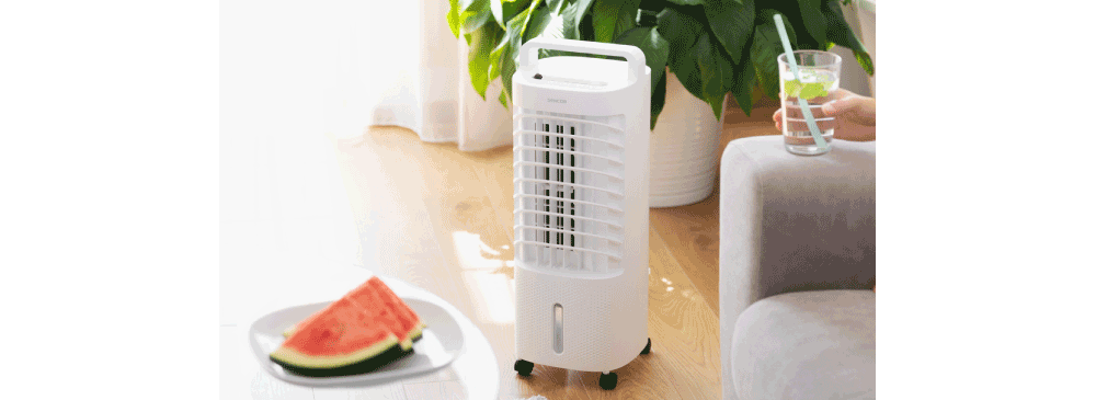 Ochladzovač vzduchu v obvačke, kde si osoba vychutnva studen npoj a na stole červen meln.