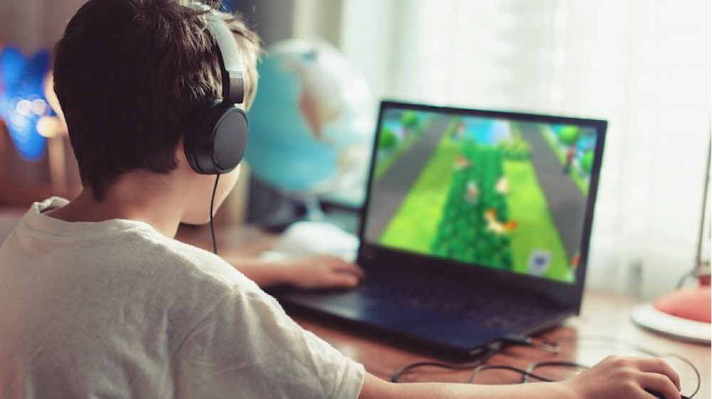 Chlapec použva Lenovo laptop na hranie hier