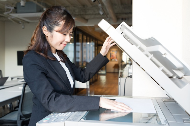 Multifunkčn tlačiareň, ktor žena využva na koprovanie dokumentov.