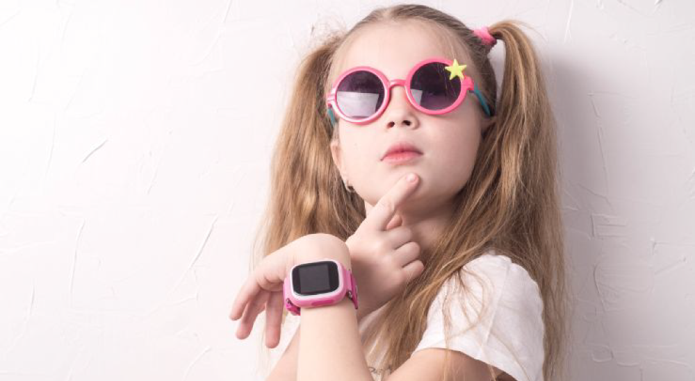 Dieťa m na ruke smart hodinky v ružovej farbe