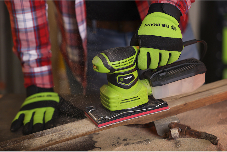 Muž opracovva drevo s pomocou vibračnej brsky značky Fieldmann.
