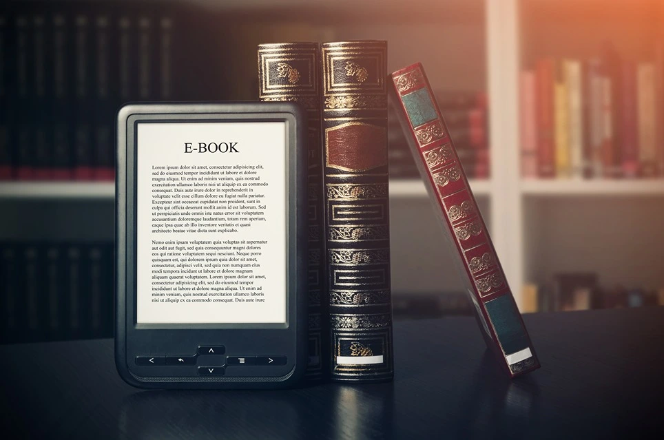 Elektronická čítačka kníh opretá o klasické knihy.