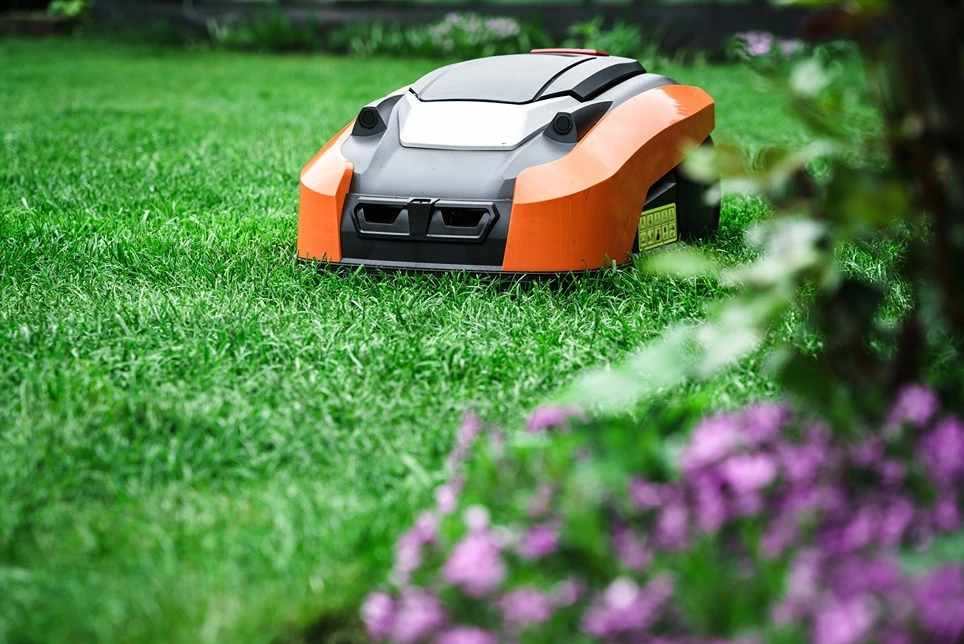 Robotická kosačka na trávniku počas práce.