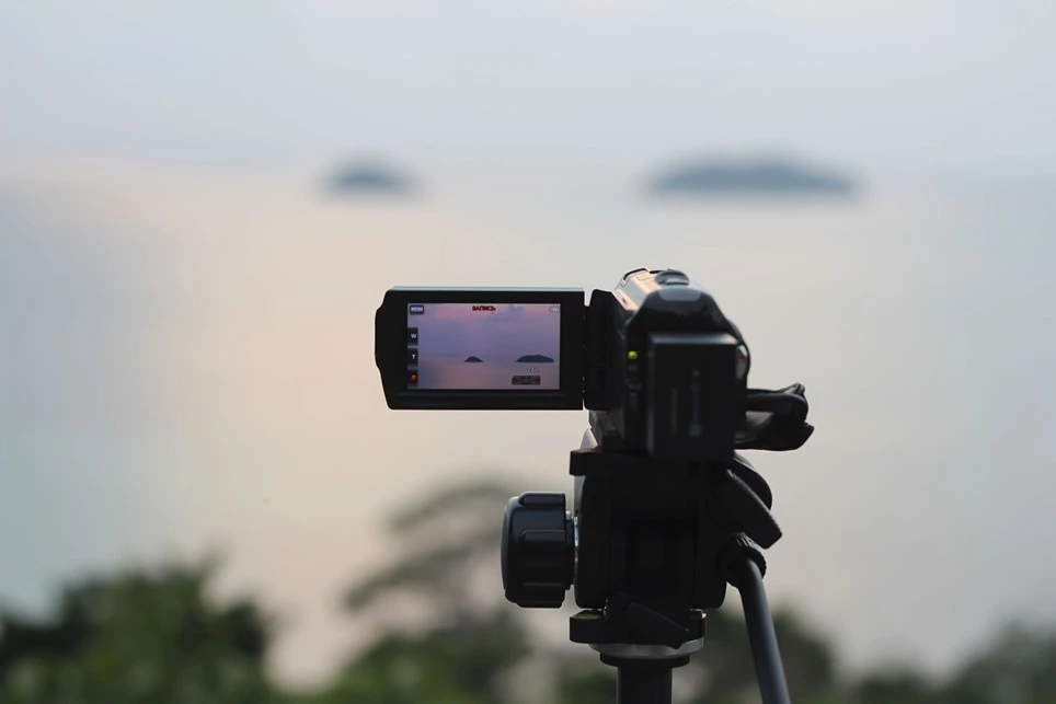 Digitálna kamera na statíve zameraná na západ slnka.