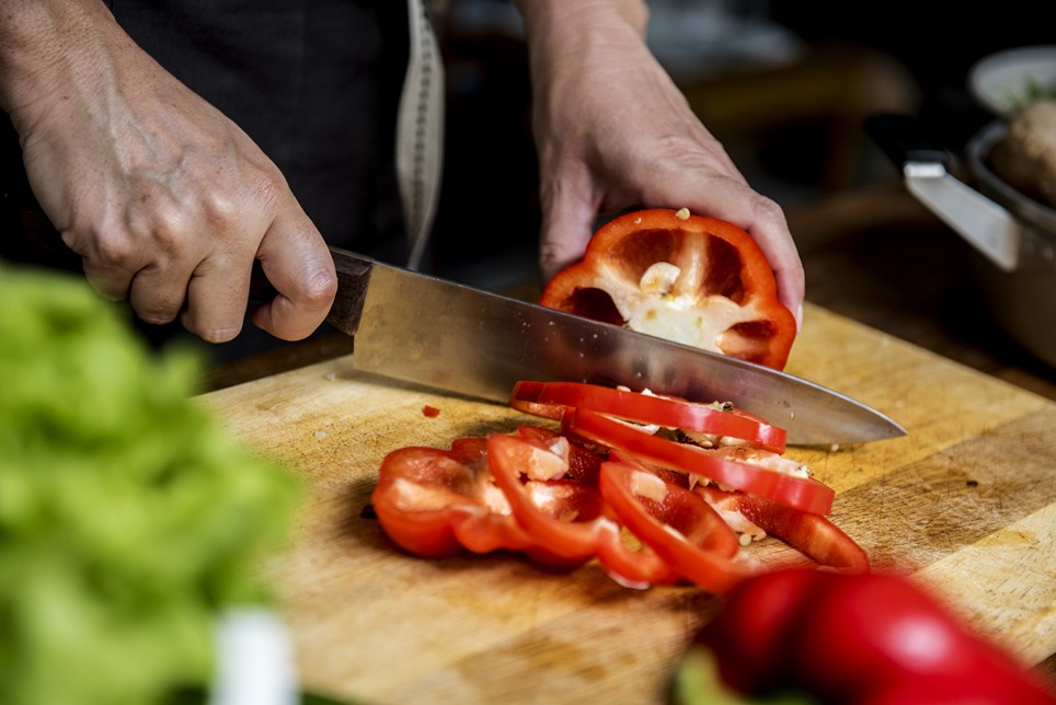Osoba krája pomocou kuchárskeho noža papriku.