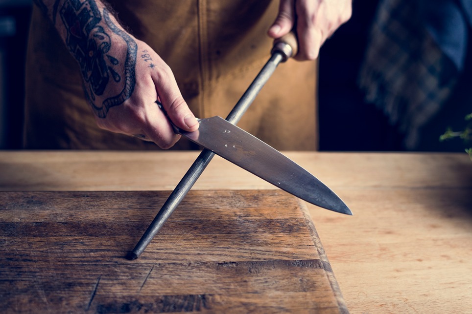 Osoba brúsi nôž pomocou ocieľky na nože.