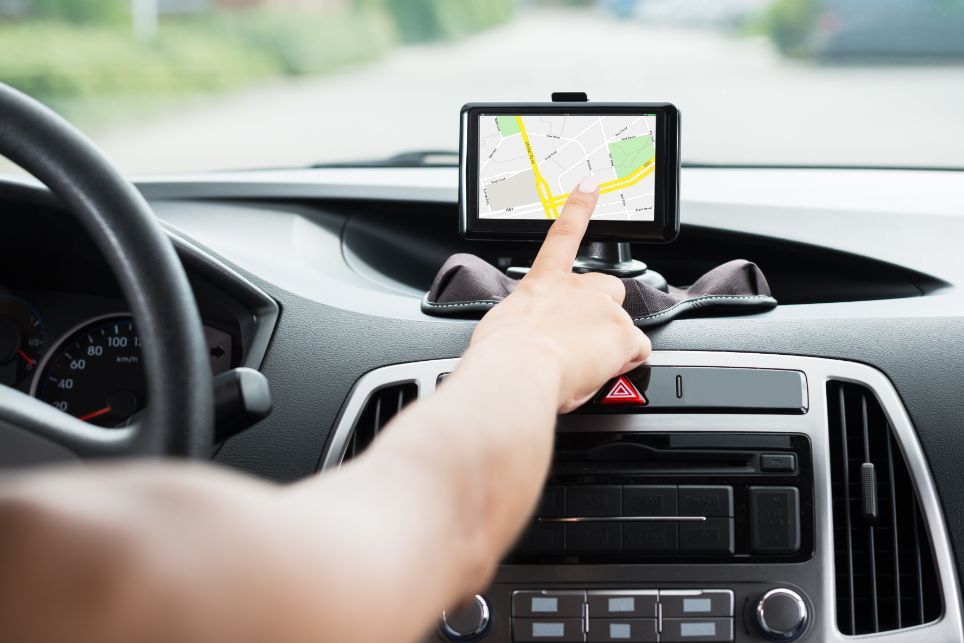 Osoba si nastavuje GPS navigáciu v aute.