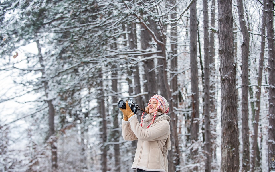 Zachytenie zimy. Žena fotografka s fotoaparátom.